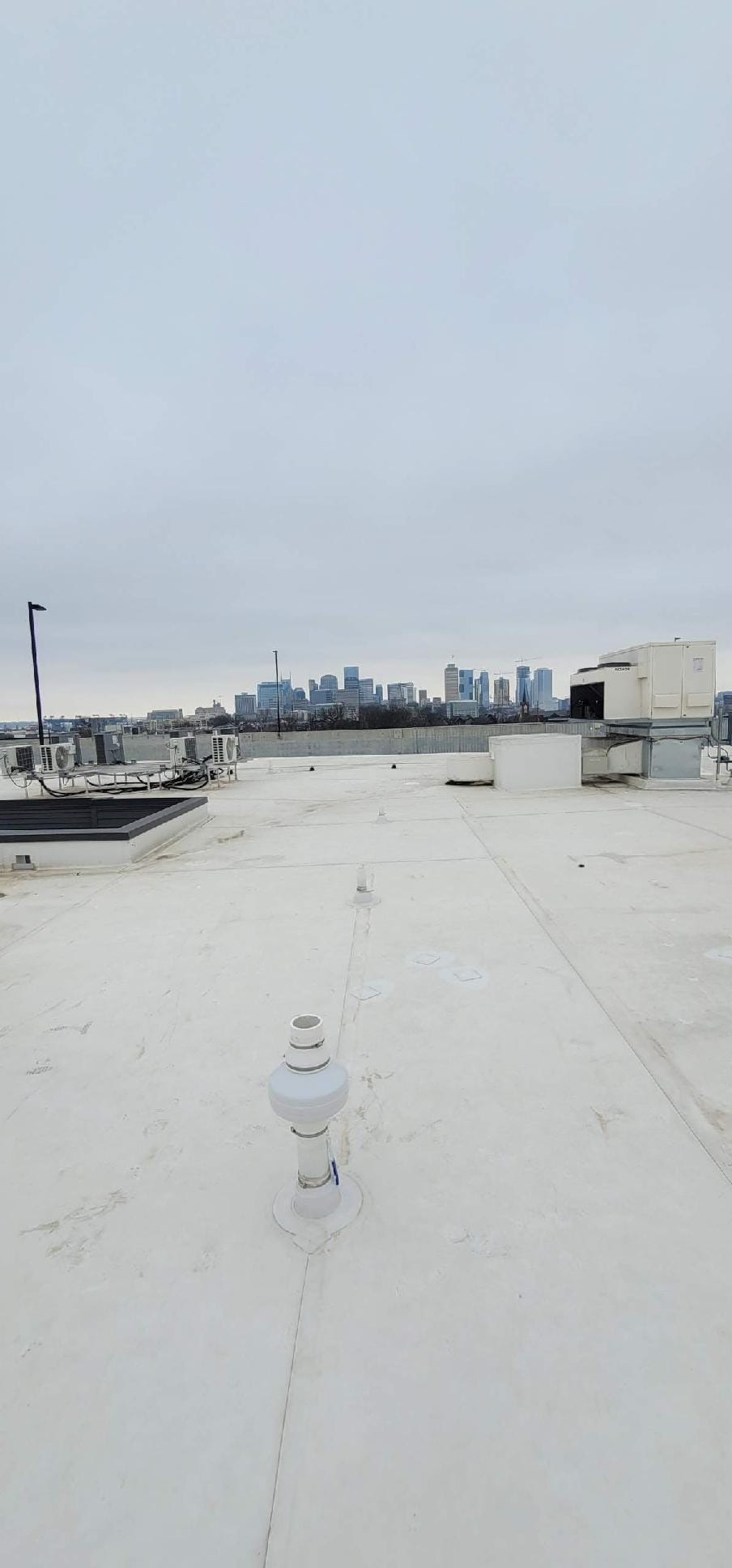 Rooftop Radon Mitigation System with City Skyline
