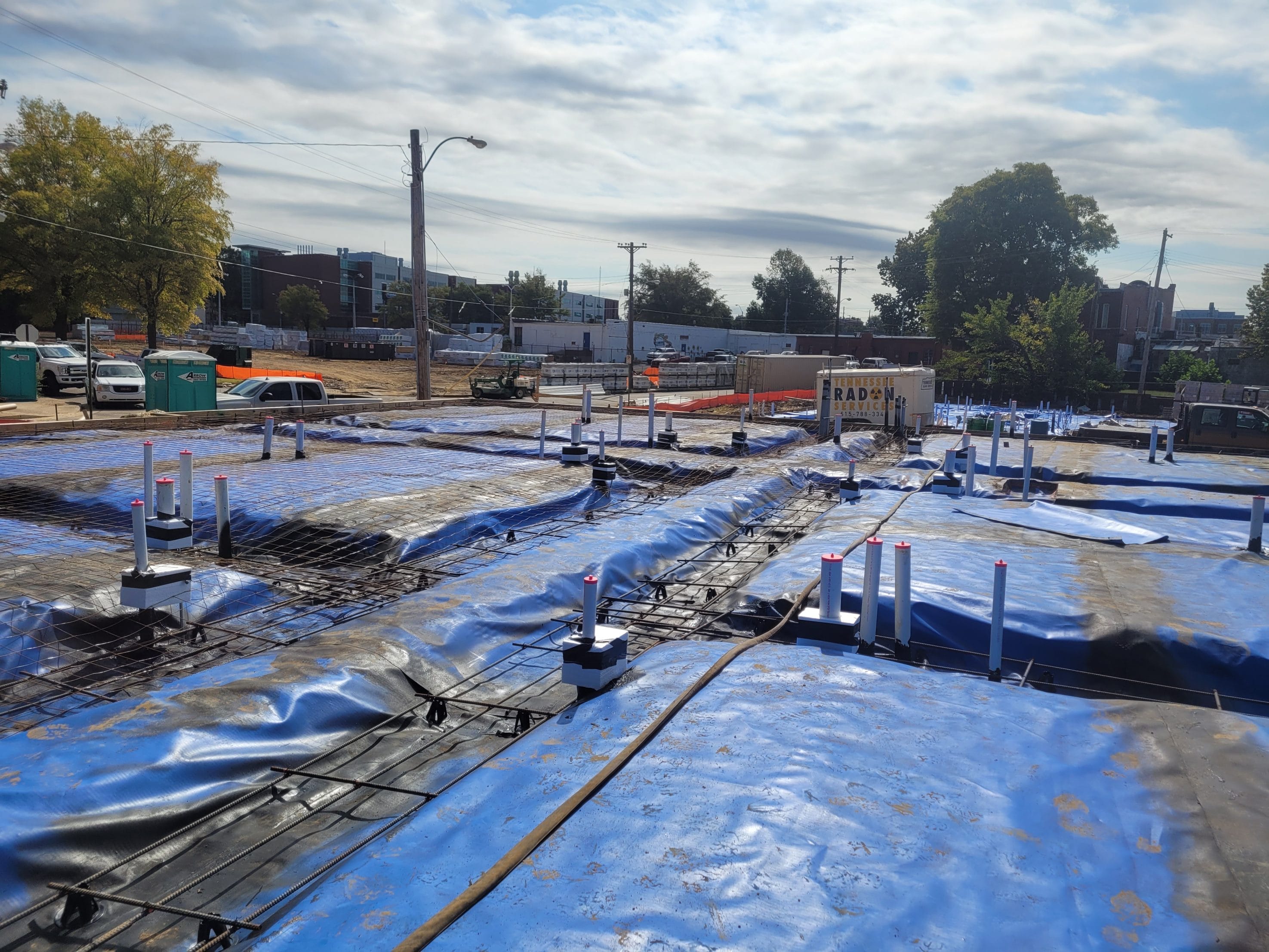 Construction Site with Blue Vapor Barrier Sheets and Piping
